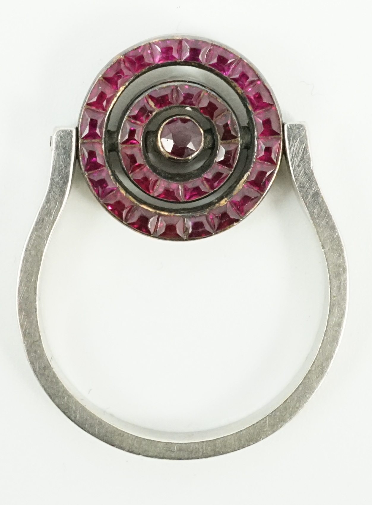 A platinum?, ruby and diamond cluster set swivelling target ring